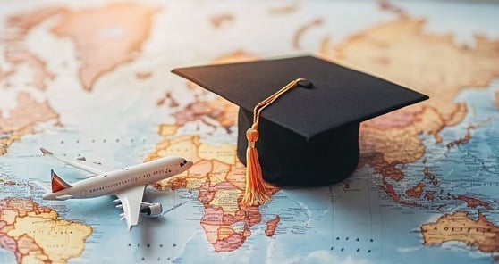 Graduation cap and airplane model standing on world map.