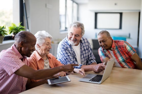 Senior men and woman using laptop.