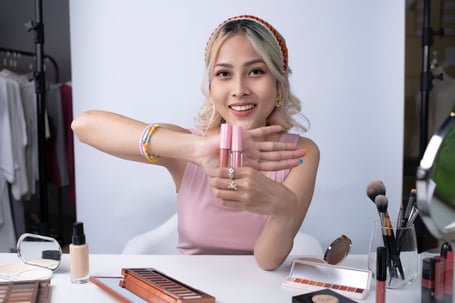 Beauty influencer using live social media to review cosmetic products and connect with followers in real time.