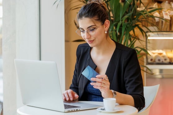 Woman with a credit card in her hand and a laptop.