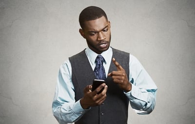 Serious man looking at phone.