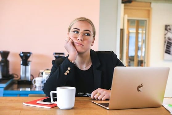 Frustrated woman at a desk with a laptop.
