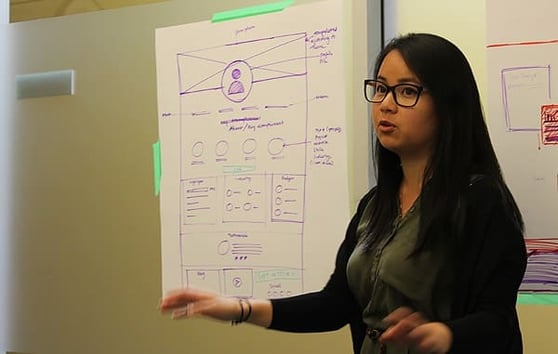 Marketing professional presenting a UX wireframe for optimizing sales leads services and improving conversions.