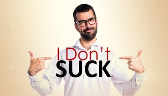 Man pointing to himself with both hands, with the words I Don't Suck on his chest.