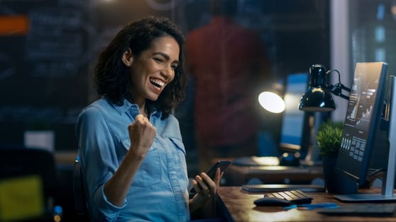 Woman Uses Mobile Phone, Has Great News and Shows "Yes" Gesture