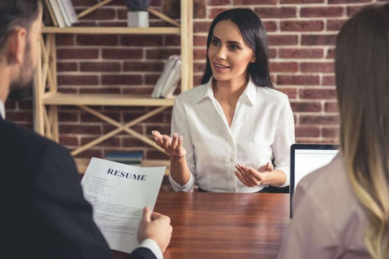 Woman being interviewed and handing her resume.
