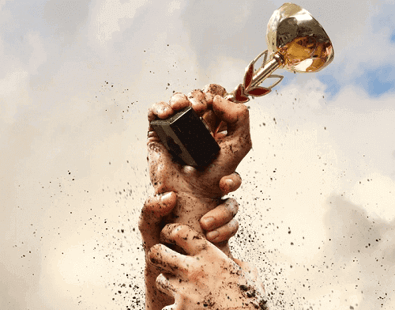 Multiple hands holding up an award